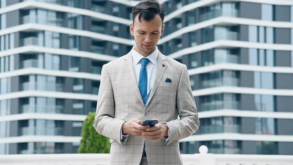 Stock Trader In Suit Holding Smart Phone In Hands.