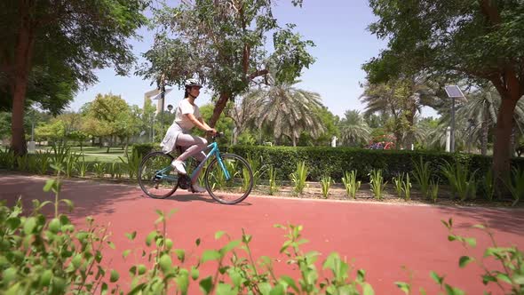 Woman Rides a Bicycle in the Park