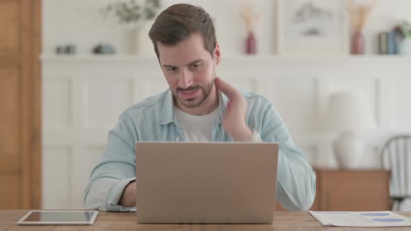 Distressed Young Man Feeling Frustrated While Working on Laptop alt