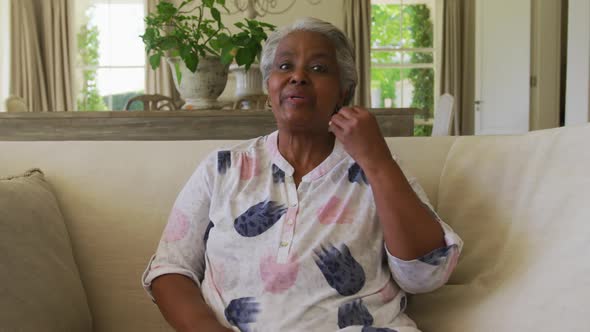 Portrait of african american senior woman talking looking at the camera at home alt