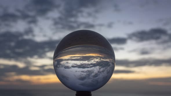 Time Lapse Clouds Above The Sea In Crystal Ball At Twilight. alt