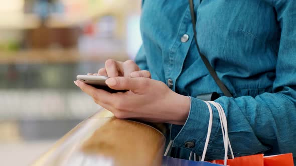 Woman using mobile phone during shopping alt
