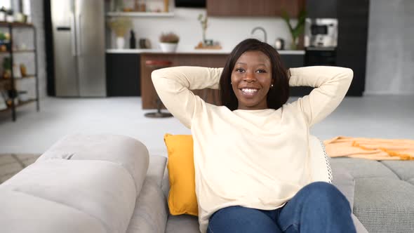 AfricanAmerican Woman Rest at Home Serene Ethnic Female Sitting on the Comfortable Couch