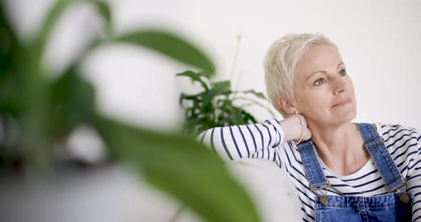 Mature woman relaxing on couch alt