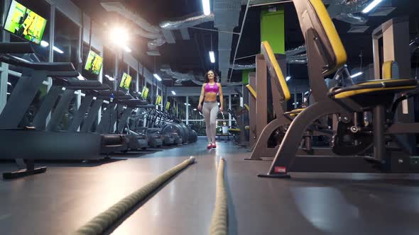 Young woman exercising using skipping rope in gym. Athletic woman training hard at the gym. alt