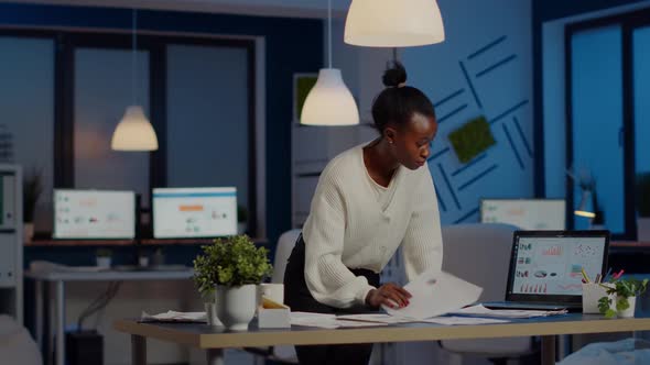 Black Bookkeeper Working on Financial Reports Checking Statistics Graphs alt