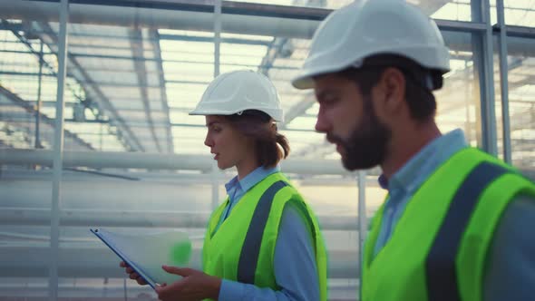 Factory Supervisors Inspecting Manufacture Wearing Uniform Collecting Data alt