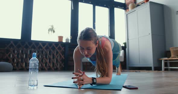 Beautiful Sporty Determined Blonde Woman Doing Elbow Plank Exercise at Home To Keep Healthy and Fit alt