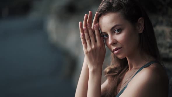 Portrait of Sensual Young Woman Runs Her Hand Through Hair Looks at Camera alt