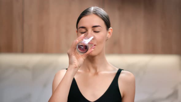 Portrait of Woman Smiling Drinking Pure Water From Glass alt