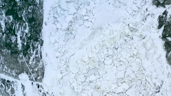 Top Down Aerial Footage of Ice Melting In A Warming Lake. Slow Drone Video of Cracked Ice In Water. alt