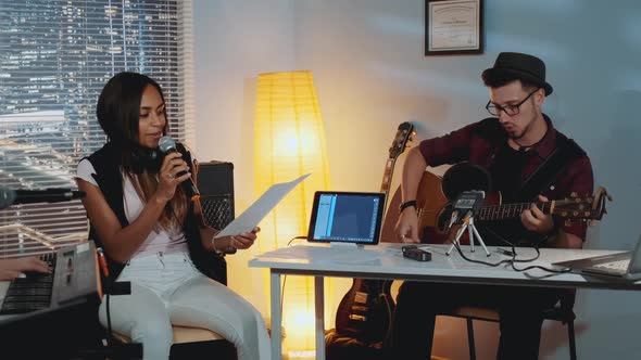 Modern Musical Band Rehearsal: Musicians Amending Chords of Music Song on a Piece of Paper alt