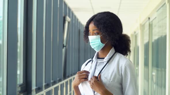 African American Woman Physician or Nurse Posing with Stethoscope in Protective Mask Looking at alt