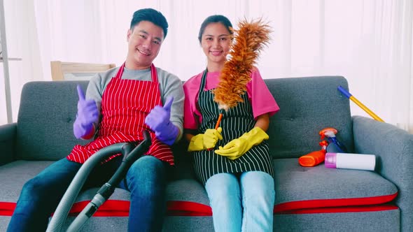 Husband and wife cleaning their room. Happy Asian couple spending time together at home. alt