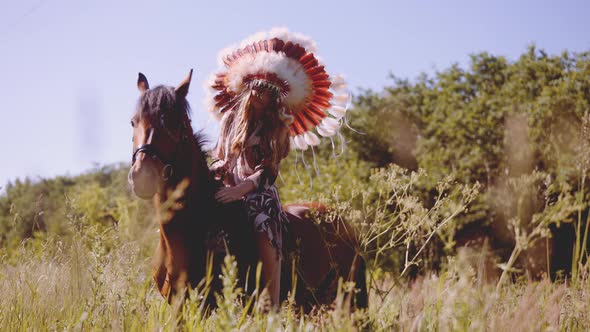 Girl In Native American Headdress On Horseback In Meadow alt