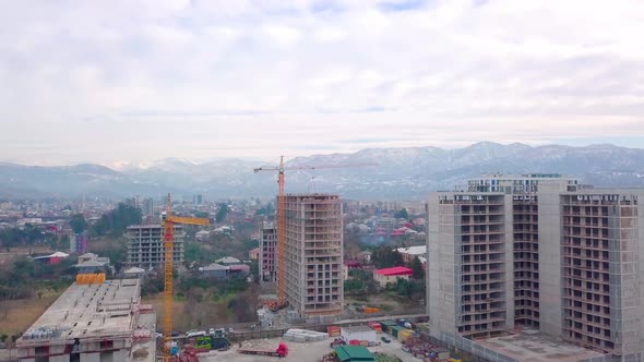 Drone view of construction of multi-storey buildings background of mountains. alt