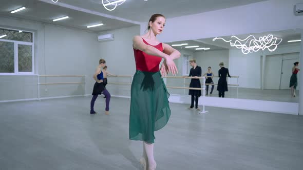Concentrated Young Slim Ballet Dancer Rehearsing Pas and Tendu Movements in Studio with Ballerinas alt