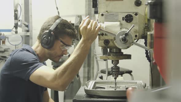 Man using machine tool in factory