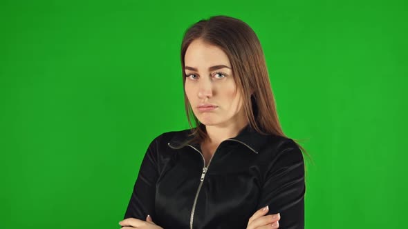 A Sad Woman Looks at the Camera on a Green Screen