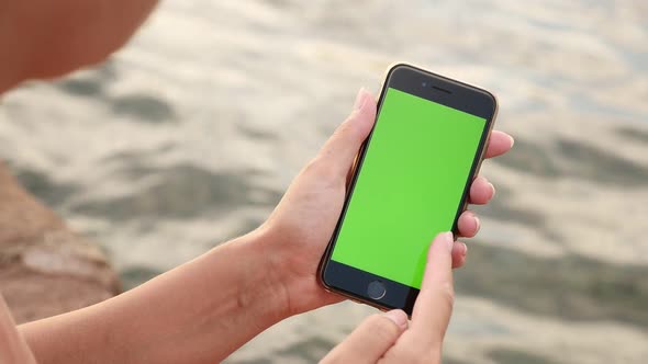 NICE, FRANCE - JULY 2017 Woman holds  chroma key  phone holding by the sea  slow-mo alt