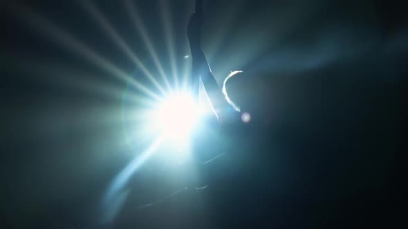 Blonde with Sexy Shape is Gracefully Rotating on Pole Dancing Striptease in Dark with Strobing Beams alt