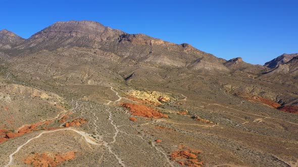 Aerial view of a mountainous landscape with in Red rocks and dirt roads, in Arizona, USA - reverse, alt