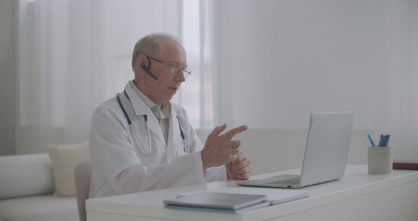Elderly Experienced Male Professor of Medicine Is Lecturing Online Sitting at Office, Teaching alt