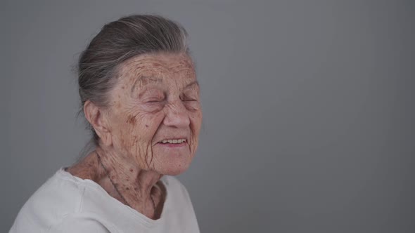 Portrait of Caucasian Senior Woman 90 Years Old with Deep Wrinkles and Gray Head Happy with Tooth alt