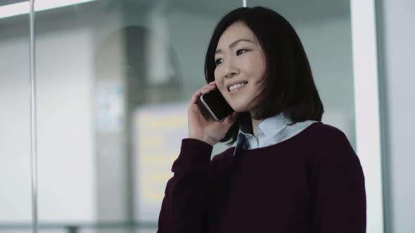 Japanese business woman in office talking on phone