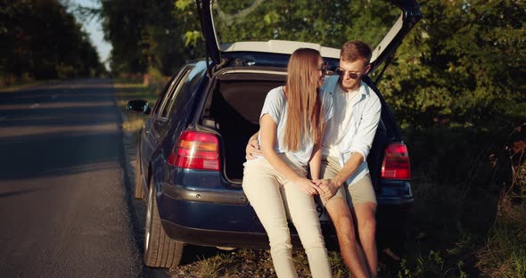 Couple Sitting in Car Trunk and Relaxing