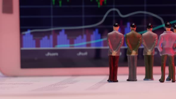 Business Figurines Watching a Chart