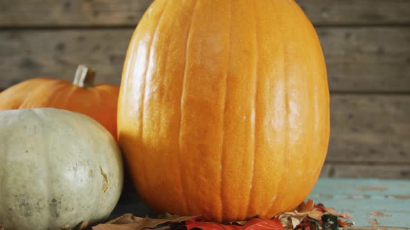 Composition of halloween orange pumpkins against rustic wooden surface alt