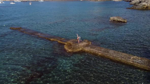 Unrecognizable woman doing yoga at seaside alt