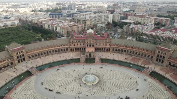 Descending aerial shot of distinctive Spain Square, city view; Seville