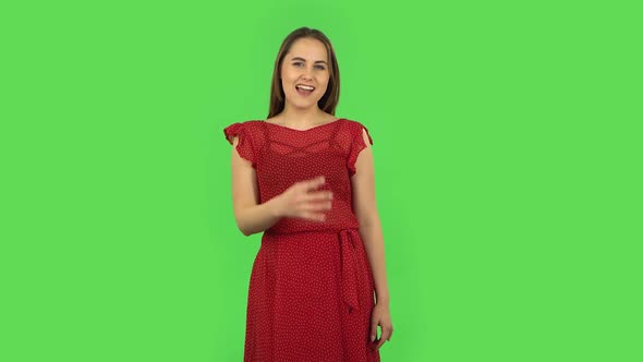 Tender Girl in Red Dress Is Making a Rock Gesture and Enjoying Life. Green Screen alt