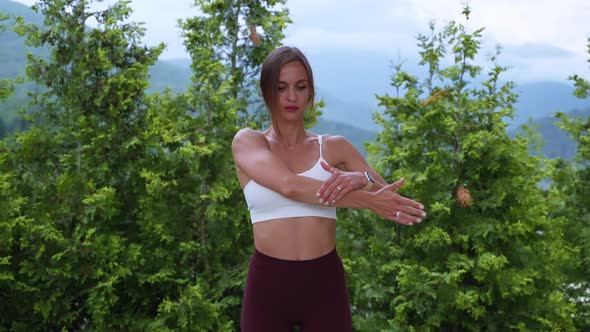 Female Athlete Doing Warmup Arm Stretching in Open Air