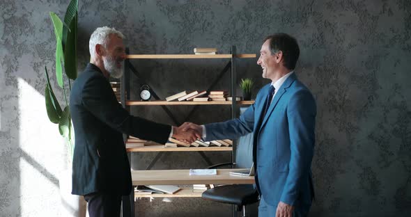 Two Business Men Shake Hands When Meeting at Office Agree to a Deal or Say Hello alt