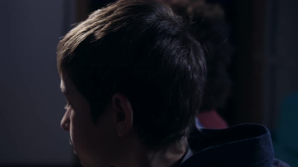 Faces in Profile of Eating Teen Boys Playing Game