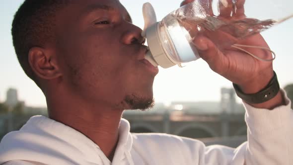 Tired Man Sipping Water After Workout alt