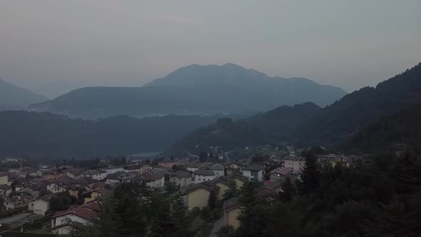 Aerial panoramic view of Levico Terme, Italy, during sunrise with drone flying sideways alt