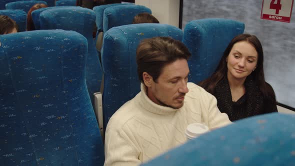 A Middleaged Couple are Talking and Smiling in a Train Carriage