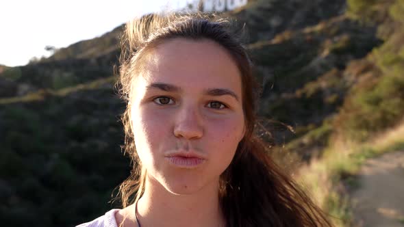 Cheerful Young Girl Blow Kiss and Smile with Windy Hair Face Portrait