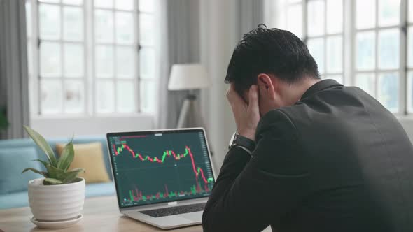 Asian Businessman Upset After Seeing Stock Prices Fall In The Trading On Computer Screen alt