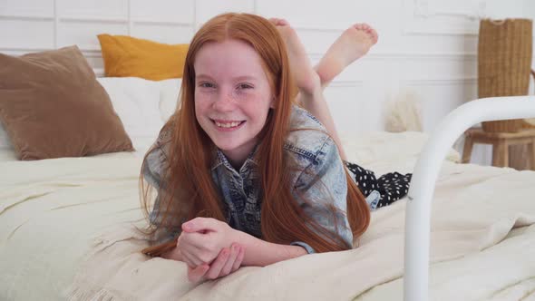 Happy Ginger Girl Smiling on Cozy Bed at Home