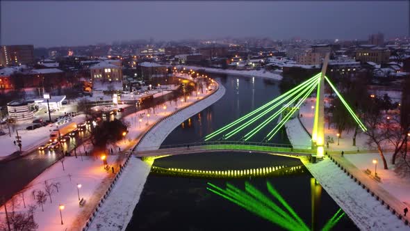 Illuminated bridge on winter river in Kharkiv city