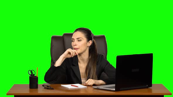 Pretty Woman Sits at the Workplace with a Notebook and Pencil, Thinks Hard, Sighs Irritably and alt