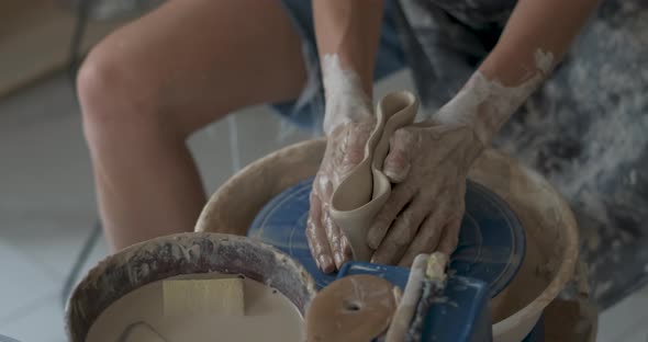 Unrecognisable Pottery Female Master Destroys Crafted Clay Jug on a Pottery Wheel in Studio