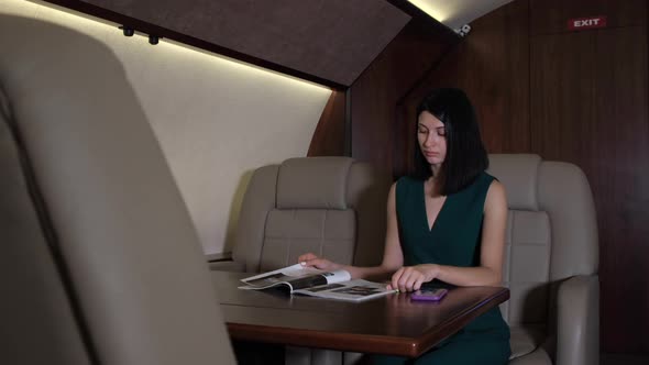 A Young Business Woman Looks At A Magazine Works Flies In Her Business Jet Her Personal Plane alt