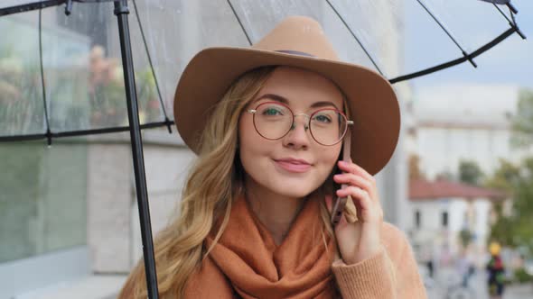 Closeup Young Girl Student Walking in City with Umbrella Woman Cheerfully Talking on Mobile Phone alt