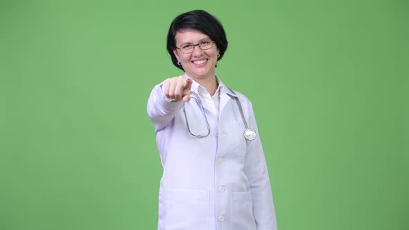 Beautiful Woman Doctor with Short Hair Pointing at Camera alt